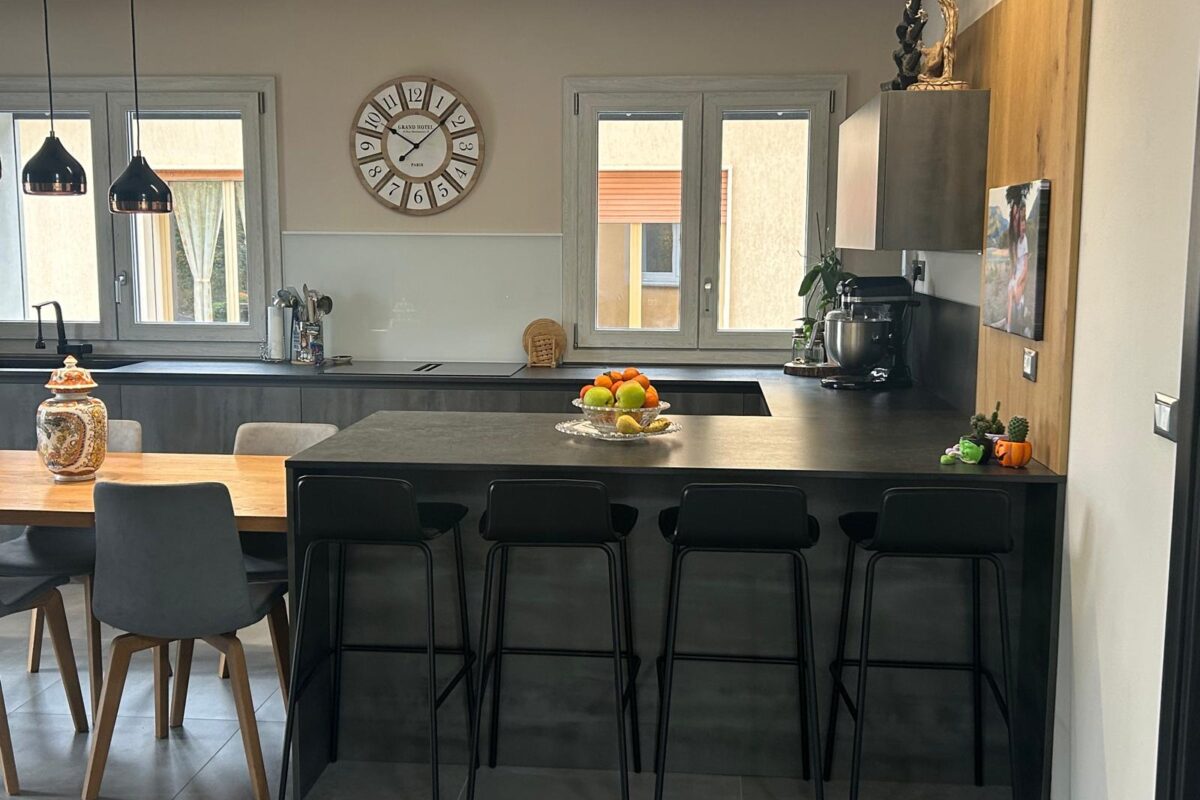 cucina moderna con isola snack e tavolo in legno massello