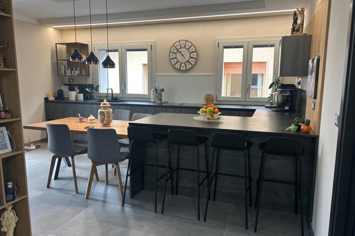 cucina moderna con isola snack e tavolo in legno massello