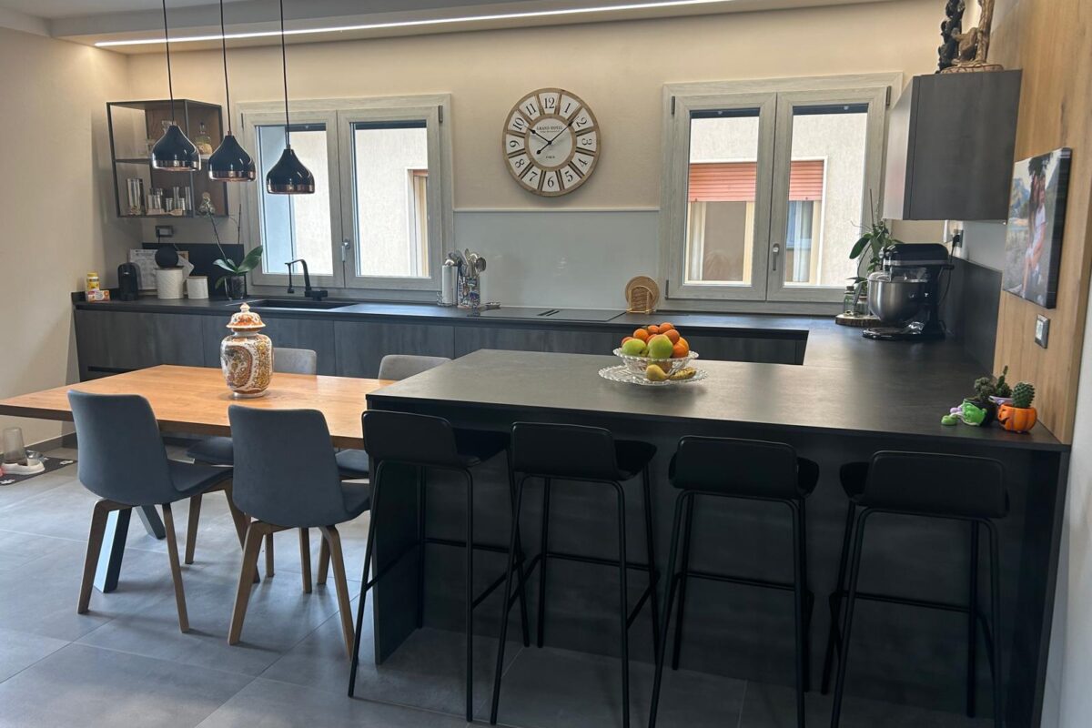 cucina moderna con isola snack e tavolo in legno massello